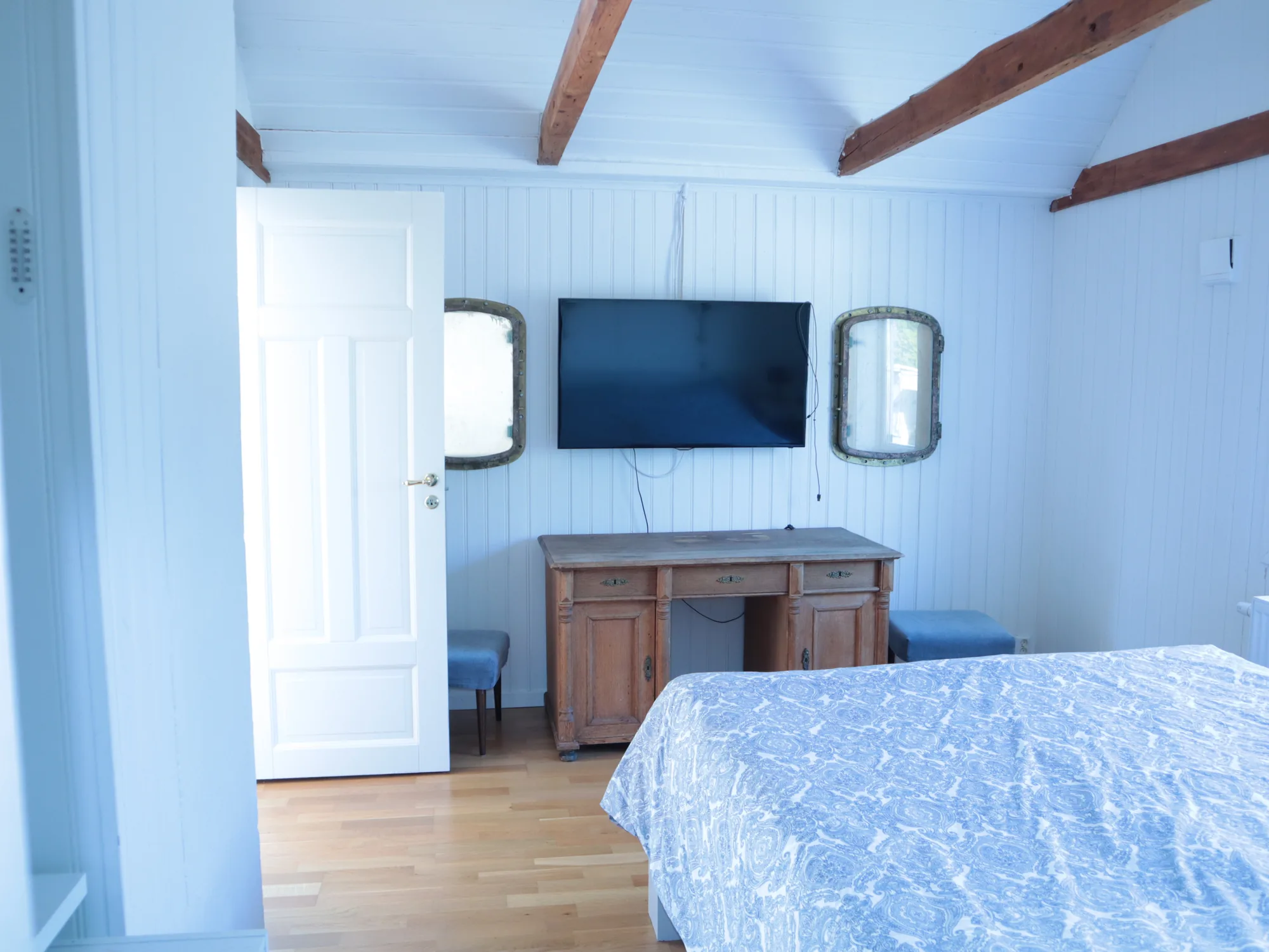 Schlafzimmer mit Doppelbett, TV und antikem Sekretär